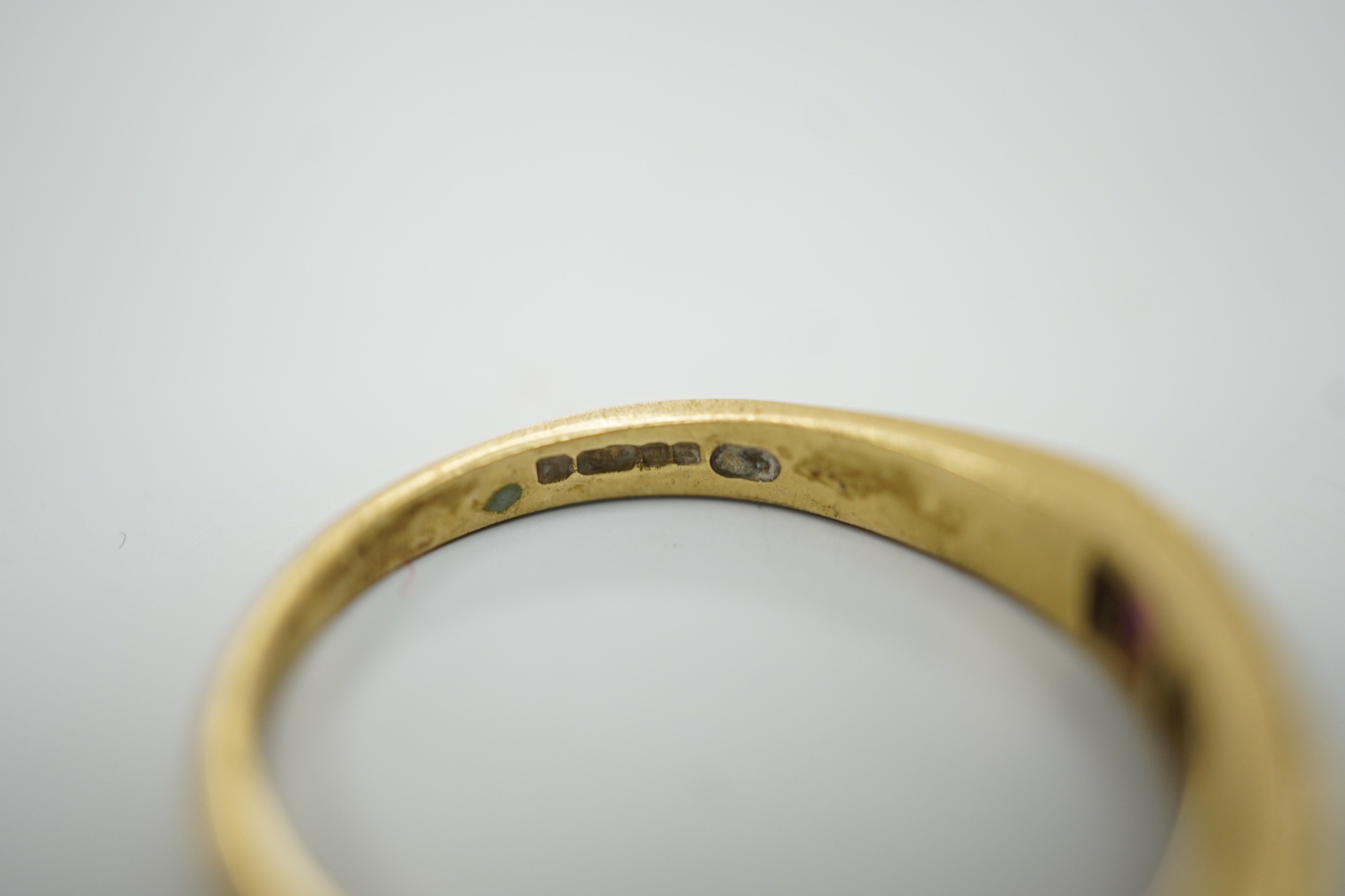 A modern 18ct gold, four stone ruby and three stone diamond set half hoop ring, size L/M